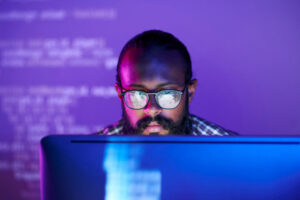 programmer in front of bright computer screen